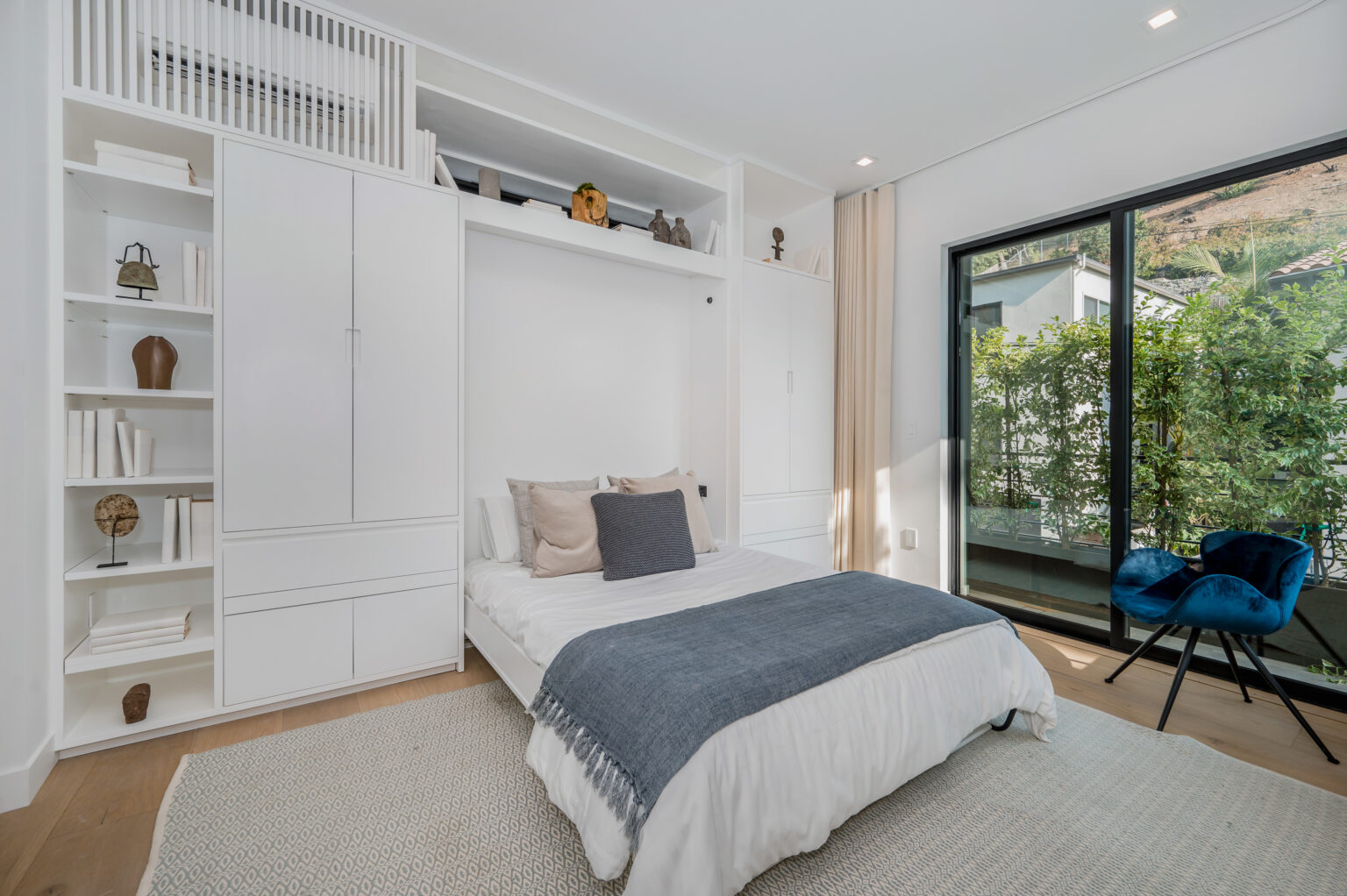 Split king adjustable bed made up in a bright modern bedroom with built-in shelving